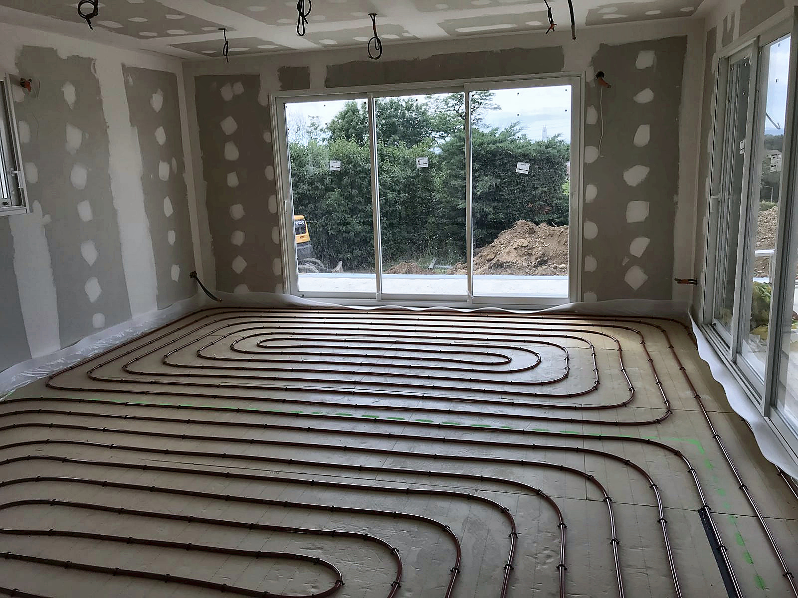 Chantier : plancher chauffant déroulé dans la future pièce de vie du sous-sol, à Jonage